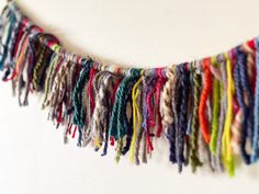 multicolored yarn hanging from the side of a wall