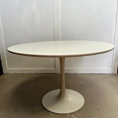 an oval white table sitting on top of a floor