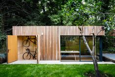 a bike is mounted to the side of a wooden structure in front of a tree