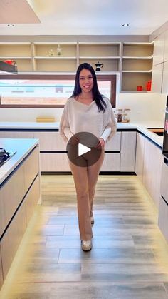 a woman standing in the middle of a kitchen