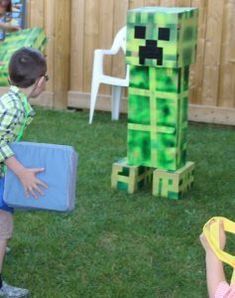 two young children playing in the yard with some paper mache structures on it's lawn