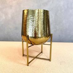 a large metal vase sitting on top of a table