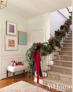 a christmas garland on the banisters and stairs is decorated with red, white and green ribbons