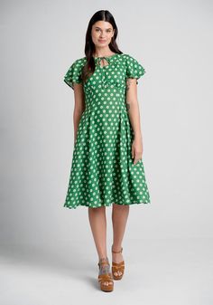 Fall in love with springtime in this gorgeous green A-line dress from Timeless London! Made from a flowy woven fabric with an all-over white daisy print, this vintage-inspired dress features 2-tiered flutter sleeves, a stylish keyhole neckline with tie-string closure, a flattering princess seamed bodice with delicate shirring at the bust, and a flowy knee-length skirt with handy side pockets. 40s Dresses, Dresses 20s, Polka Dot Dresses, Dresses 50s, 1940s Fashion Dresses, Vintage Polka Dot Dress, 40s Dress