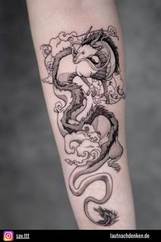 a black and white dragon tattoo on the arm