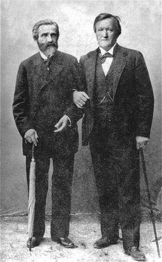 two men standing next to each other holding umbrellas and canes in their hands