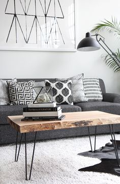 a living room filled with furniture and a wooden table in front of a couch on top of a rug