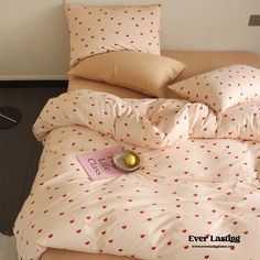 an unmade bed with hearts on it and a tag that says love is in the corner