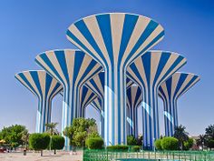 the large blue and white building has arches on it's sides, as well as trees