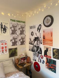 a bedroom with posters on the wall and lights strung from the ceiling over the bed