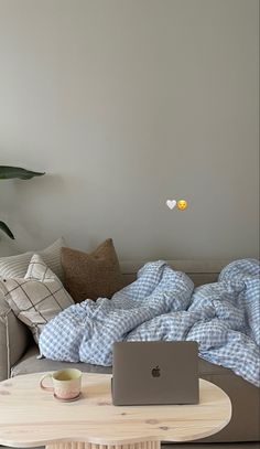 a living room with a couch, coffee table and laptop computer on the top of it