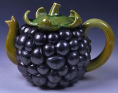 a ceramic figurine of a black grapes with green accents on it's head