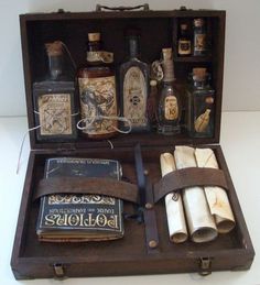 an old wooden box filled with bottles and other items on top of a white table