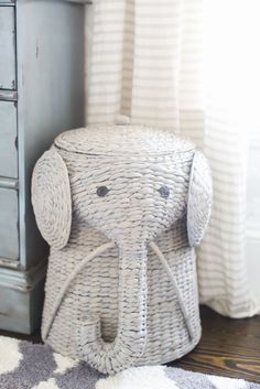 an elephant basket sitting on the floor next to a dresser