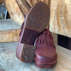 a pair of brown shoes sitting on top of a wooden floor