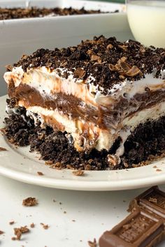 a piece of cake sitting on top of a white plate next to a glass of milk