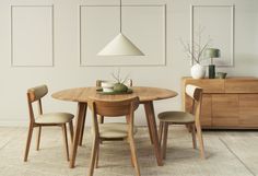 a wooden table with four chairs and a white vase on top of it next to a dresser