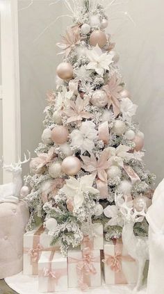 a white christmas tree decorated with pink and silver balls, bows, ornaments and ribbons