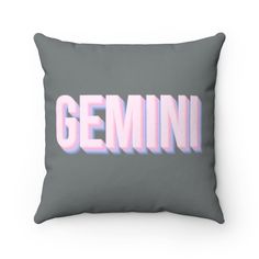 a grey pillow with the word gemini in pink and white letters on it