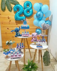 two tables topped with blue balloons and desserts