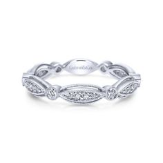 a white gold wedding band with diamonds on the sides and leaves in the middle,