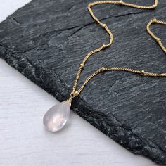 Rose Quartz Necklace, Dainty Gold Necklace, Pink Teardrop Pendant, Minimalist Layering Jewelry, Satellite Ball Chain, Delicate Gift for her This feminine and dainty necklace features a flawless light pink rose quartz teardrop suspended from a delicate 14k Gold Filled or Sterling Silver satellite chain. This is a 100% natural Rose Quartz and full of healing properties.  This necklace is simply perfect for everyday wear and is perfect for layering with other pieces in your collection. About this N Dainty Rose Gold Drop Necklace, Dainty Rose Gold Teardrop Pendant Charm Necklace, Rose Gold Necklace With Delicate Teardrop Pendant, Dainty Rose Gold Drop Necklace With Clavicle Chain, Delicate Pink Teardrop Pendant Necklace, Delicate Rose Gold Teardrop Necklace, Pink Teardrop Pendant Necklace In Dainty Style, Dainty Rose Gold Teardrop Pendant Drop Necklace, Dainty Pink Teardrop Necklace