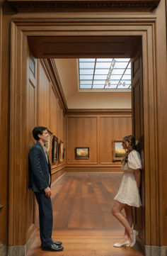 a man and woman standing in an art gallery