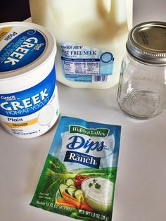 ingredients to make greek yogurt and dips on a white counter top with milk