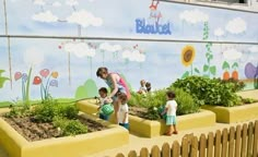 two children and an adult are standing in front of a painted mural on the side of a building