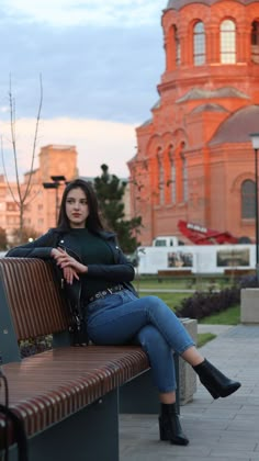 a woman sitting on a bench in front of a building