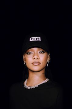 a woman wearing a black hat with the word petty on it's side and her eyes closed