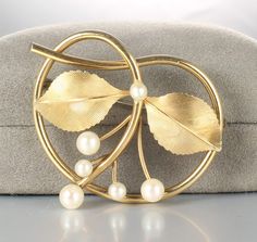 Lovely circa 1960s Krementz brooch. It is gold filled and showcases five beautiful natural pearls in a leaf and vine design. Dimensions are 1 5/8 inches by 1 1/4 inches. Brooch is in very good vintage condition and super sweet! Gold Pearl Brooch Jewelry, Elegant Gold Metal Brooches, Luxury Gold Brooch With Pearl Pendant, Vintage Pearl Gold Brooches, Luxury Vintage Brooch With Pearl Pendant, 1960s Jewelry, Figural Jewelry, Bee Brooch, Vine Design