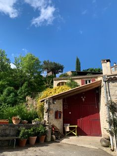 a red garage with potted plants on the roof