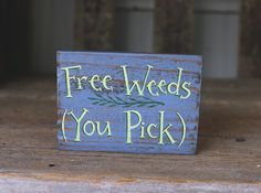 a wooden sign that says free weeds you pick on the side of a wood table