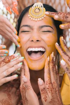 a woman with henna on her face and hands around her