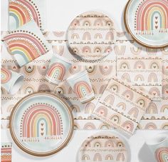 an array of colorful plates and cups on a table with rainbows printed on them