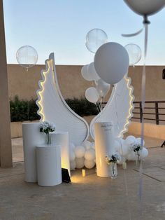 balloons and decorations are on display at the entrance to an outdoor venue with white walls