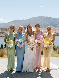 a group of women standing next to each other on top of a cement floor covered field