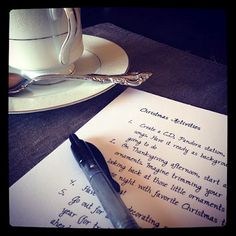 a pen sitting on top of a piece of paper next to a cup and saucer