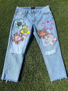 Don't want to wear what everyone else is wearing?  These super cute Patched upcycled mens Rola boyfriend cut jeans are perfect for the unique trendsetter you are!  Wear them oversized if you're smaller than a 36 just belt them and you'll be good to go!  There are assorted flower patches on the front  sourced from thrifted and vintage fabrics.  Pair them with a solid top,  your fave converse and you're good to go.  If you would like these cut shorter with a raw frayed hem just lmk your inseam and I will cut and fray for you.  Waist   37 inches Rise  11.5 inches Inseam  26 inches  hips  48 inches Back rise  16 inches  Thigh  26 inches  stretch - nope Rise is the most important measurement, as it determines where all the other measurements will fall. Please compare these measurements to your Patchwork Relaxed Fit Jeans For Spring, Spring Patchwork Relaxed Fit Jeans, Spring Patchwork Straight Leg Jeans, Spring Patchwork Straight-leg Jeans, Spring Patchwork Cotton Jeans, Casual Recycled Denim Bottoms With Patches, Casual Bottoms With Patches In Recycled Denim, Spring Denim Bottoms With Patches, Casual Jeans With Collage Stitching For Spring