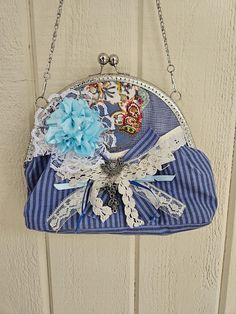 kiss lock purse, shabby chic embellished with flower, lace,ribbon and jewelry. hand stitched silver frame, features optional silver chain. Kiss Lock Purse, Chic Purses, Jewelry Hand, Flower Lace, Blue And Grey, Lace Ribbon, Silver Frame, Clutch Handbag, Grey Stripes