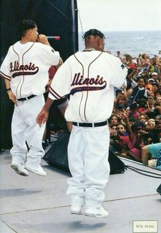 two baseball players standing on the side of a stage in front of a large crowd