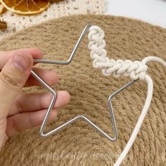 someone crocheting a star ornament with yarn