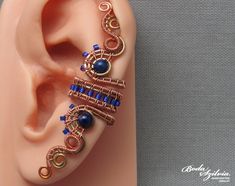 Wire wrapped adjustable ear cuff with lapis lazuli stones, no piercing required. Lapis is one of the oldest spiritual stones known to man, used by healers, priests and royalty, for power, wisdom and to stimulate psychic abilities and inner vision. It represents universal truth. It was one of the most often used stones in ancient Egypt. It's made of raw copper and brass wire, seed beads and lapis lazuli stones. You can wear it on both the left or right ear. Available: - single - pair Plz, select Ear Wraps, Wire Wrapping Diy, Healing Stones Jewelry, Wrap Earrings, Steampunk Jewelry, Handmade Beaded Jewelry, Wire Weaving, Jewelry Making Tutorials, Ear Cuffs