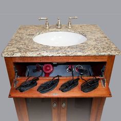 an old fashioned sink with several plugs in the cabinet and power cords attached to it