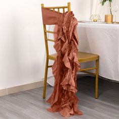 a chair that is next to a table with a white table cloth on top of it