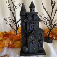 a black and white photo of a gothic - styled house with spooky trees in the background