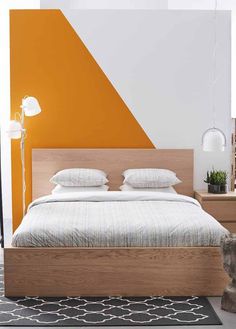 a bed with white and orange walls in a bedroom