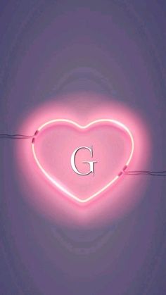 a pink neon heart with the letter g on it