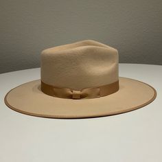 Never Worn Wide Brim Hat. Stiffened Wool Fedora With Rigid Crown Design That’s Trimmed With A Tonal Grosgrain Ribbon. Beige Fitted Felt Hat With Flat Crown, Beige Fedora With Flat Crown For Spring, Spring Beige Fedora With Flat Crown, Classic Tan Hat With Curved Brim, Classic Beige Fedora With Flat Crown, Fitted Beige Fedora With Flat Crown, Fitted Beige Fedora With Flat Brim, Classic Tan Flat Brim Hat, Beige Flat Brim Fedora